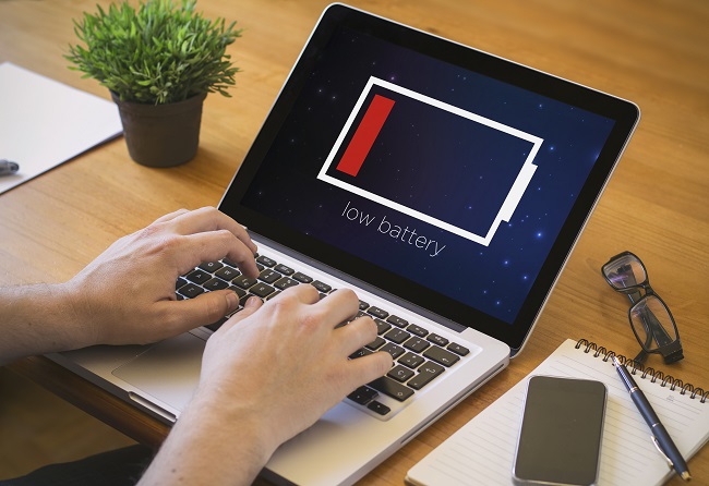 Businessman at work. Close-up top view of man working on laptop with low battery. all screen graphics are made up.